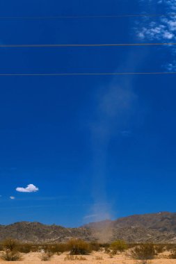 Yüksek ulaşan çöl şeytanı Maricopa city yakınındaki Yuma, arasındaki Phoenix Arizona çölde bir dikey görüntü. Enerji hatları görüntünün üst sıraya. Sıcak hava ve rüzgar toz darbe.