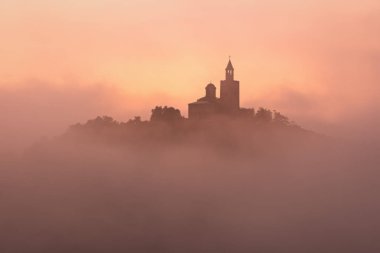 Harika bir manzara şaşırtıcı Tsarevets kalede Veliko Tarnovo, Bulgaristan üzerinde yaz aylarında sisli gün doğumu.
