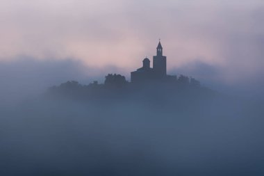 Harika bir manzara şaşırtıcı Tsarevets kalede Veliko Tarnovo, Bulgaristan üzerinde yaz aylarında sisli gün doğumu.