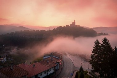 Harika bir manzara şaşırtıcı Tsarevets kalede Veliko Tarnovo, Bulgaristan üzerinde yaz aylarında sisli gün doğumu.