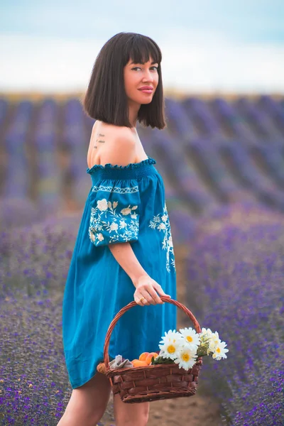 Young beautiful attractive woman in the blooming lavender fields near Plovdiv in Bulgaria. Blooming lavender flowers in Bulgaria.