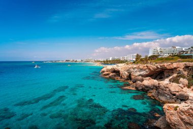 Güzel turkuaz temiz su ve ünlü turistik Ayia Napa, Paralimni, Kıbrıs inanılmaz kaya oluşumları ve kayalıklar ile güneşli bir günde mavi gökyüzü.