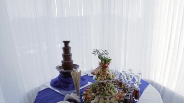 フルーツ シャンパン ジュース チョコレートの噴水とビュッフェ テーブル 結婚式のゲストの歓迎の準備 — ストック動画