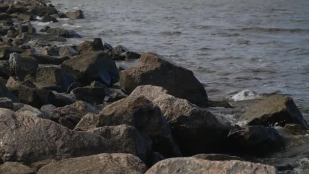 En la presa del Golfo de Finlandia sobre piedras de granito salpicando olas . — Vídeo de stock