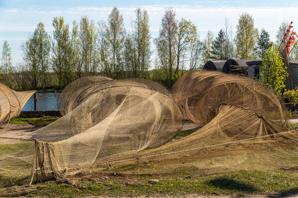 Russia. Leningrad region. Old fishing nets placed on the shore in the early morning before fishing on lake Ladoga in the city of Novaya Ladoga.