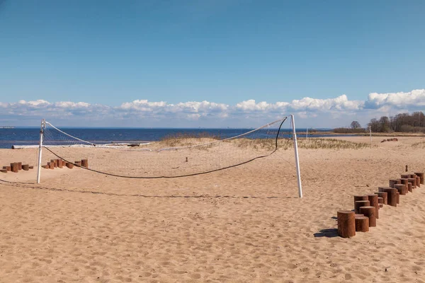 Baharda Kronstadt sahilinde voleybol sahası olan terk edilmiş kumlu bir sahil.. — Stok fotoğraf