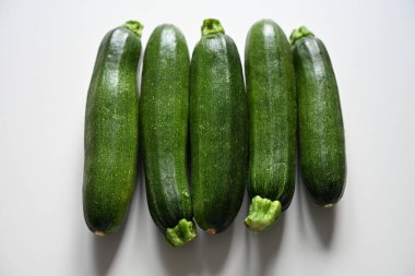 Beyaz arka planda taze yeşil kabaklar. Sağlıklı beslenme, vejetaryen diyeti, kilo kaybı, detoks, sağlık yaşam tarzı, organik sebzeler ve bitki temelli gıda kavramları için mükemmel..