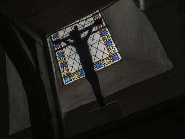 Bir pencerede kilise İsa'nın çarmıhta vitray pencere arka plan olarak bir haç silüeti