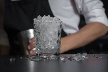 Yakın çekim yansıma bir cam ayakta kaza buz dolu dolu bar counter, barmen soğutulmuş shaker içinde belgili tanımlık geçmiş tutar.. 
