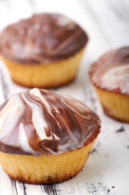 Beyaz ahşap masa yakın çekim makro üzerinde küçük kekler. Şekerli tatlı siyah ve beyaz sırlıdır. Zebra dekor ile küçük kek. Yemek festivali pudra gelen misafirler için.