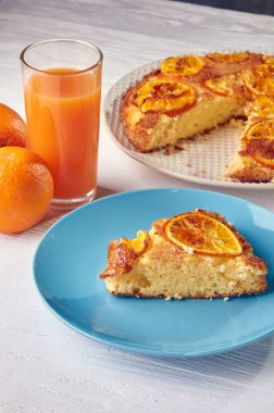 Yemyeşil bisküvi turuncu şekerlenmiş meyve ile. Portakal ve onlardan taze sıkılmış suyu bembeyaz ahşap bir masa üzerinde. Hafta sonları tipik kahvaltı.