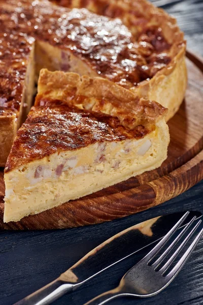 Appetizing cheese cake with sausage, ham. Snack unsweetened cake with crispy cheese crust. An unusual variant of pizza is \