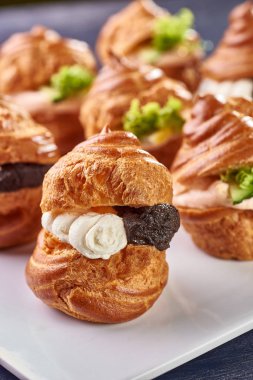 Farklı dolguları ile kokulu profiterol. Tuzlu kek aperatifler için. Mini sandviç, kanepeler sebze, et, karaciğer, sos. Enfes bir Fransız snack büfe, bayram için.