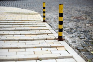 Kısıtlayıcı mesaj Yaya kaldırım ve yol arasında. Çizgili sarı-siyah renkteki küçük düşük Polonyalılar. Taş bloklar ile döşeli Avrupa'da güzel eski yolu. Şirin sokak.