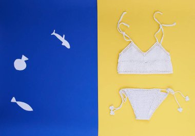 İki tonlu bir mavi ve Sarı zemin üzerine bir mayo ile yaz kolaj. Alışılmadık pahalı orijinal örme beyaz mayo. Bir çocuk tarafından yapılan kağıt balıklar.