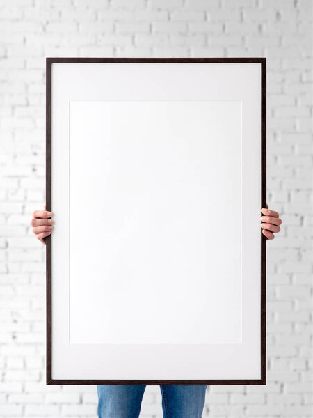 Holding frame mockup. Photo Mockup. The man hold frame. For frames and posters design. Frame size 24x36 (61x91cm).