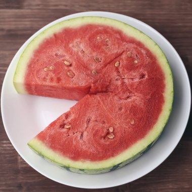 kırmızı sulu taze karpuz büyük kesilmiş parça appetizingly beyaz bir plaka üzerinde yalan söylüyor