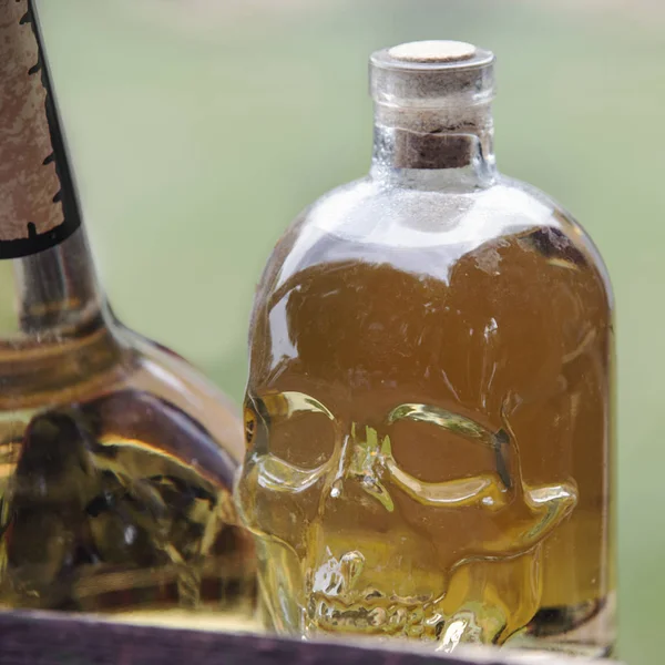 ancient glass bottle in the shape of a skull is filled with a colored liquid
