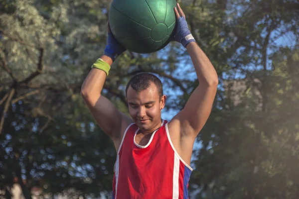 Молодой Спортсмен Выполняет Спортивные Упражнения Мячом Открытом Воздухе — стоковое фото