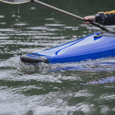 spor tekne hareket halinde mavi bir kayık, su yüzeyi bir yay ile keser