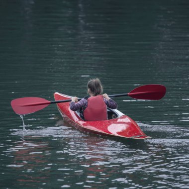 Genç Genç kız, aktif bir spor kayak teknede güzel bir nehir yönetir