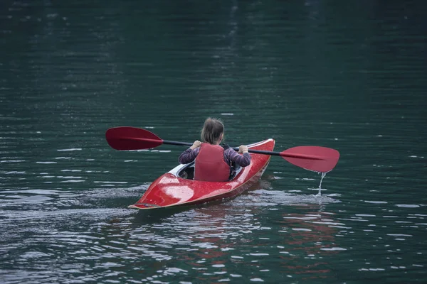 Genç Genç kız, aktif bir spor kayak teknede güzel bir nehir yönetir