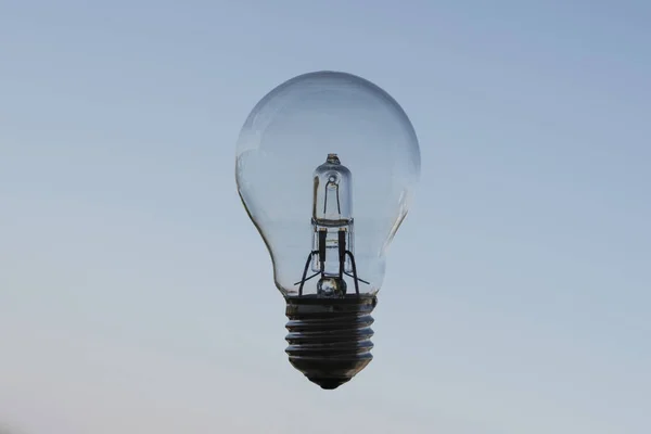 stock image Electric incandescent lamp close-up on a blue background, a symbol of creativity