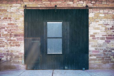 Bir grubu bir küçük kapı duvar eski taş bloklar, çatlaklar aracılığıyla ışık ışınları geçmek ile eski ahşap kapı