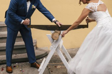 Gelin ve damat düğün geleneksel bir ritüel gerçekleştirmek, günlüğü ile büyük bir çift el testere gördüm