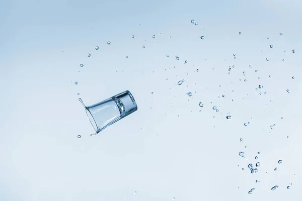 Hermoso líquido de salpicadura de un vaso de vidrio para el alcohol fuerte en —  Fotos de Stock