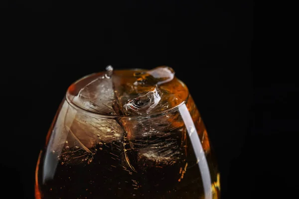 Close-up brandy glass filled with whiskey with ice. — Stock Photo, Image