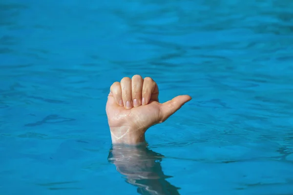 Thumb up sticking out from under the blue water, as a symbol of