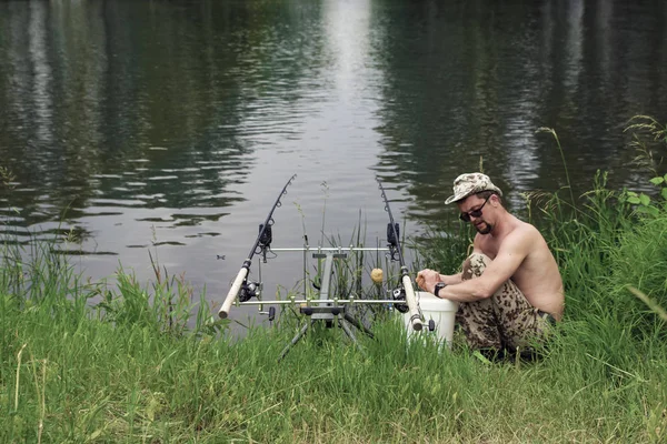 Visser aan de oever van de rivier in de zomer vangsten vis gooien — Stockfoto