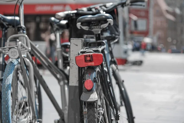 Bicicletas de pie en un aparcamiento de bicicletas en una ciudad con mucho tráfico — Foto de Stock