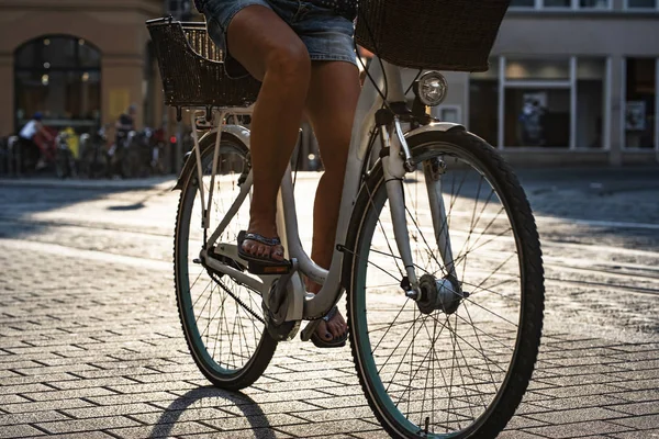 Piernas de un ciclista pedaleando en un puente de piedra de la ciudad vieja en — Foto de Stock