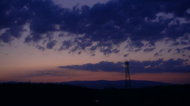 Silueta de pilón eléctrico de alto voltaje, torre en la puesta del sol, lapso de tiempo — Vídeo de stock