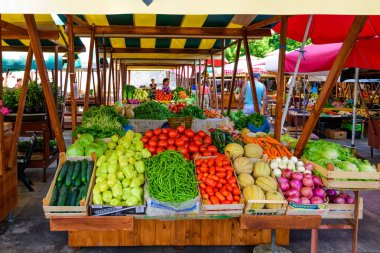 Local producers and merchants offering fresh local grown fruits and vegetables on the market clipart