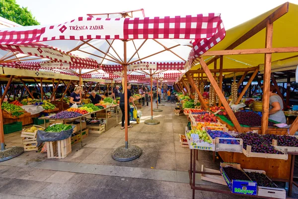 Local producers and merchants offering fresh local grown fruits and vegetables on the market — Stock Photo, Image