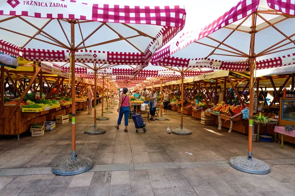 Local producers and merchants offering fresh local grown fruits and vegetables on the market — Stock Photo, Image