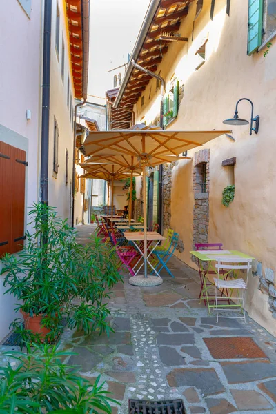 Small caffee, restaurant in narrow street in a medieval town with colorful tables and chairs