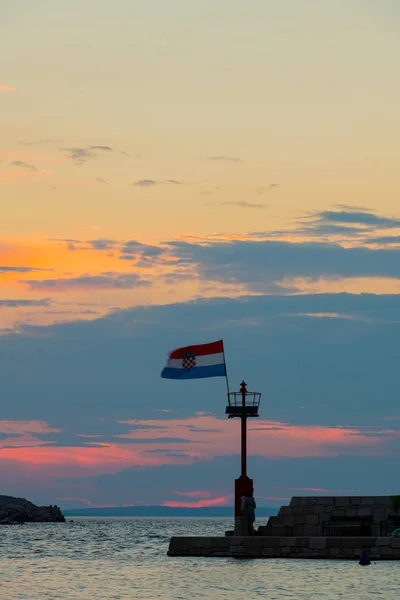 Croatian flag flying in wind at sunset in harbor — Stock Photo, Image