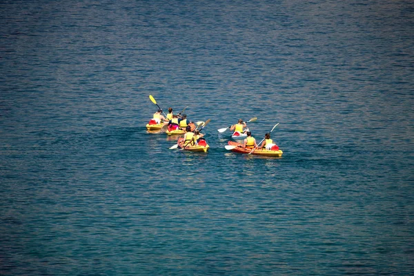 Grupo mixto de personas, mirando hacia otro lado, irreconocible, piragüismo en el mar — Foto de Stock