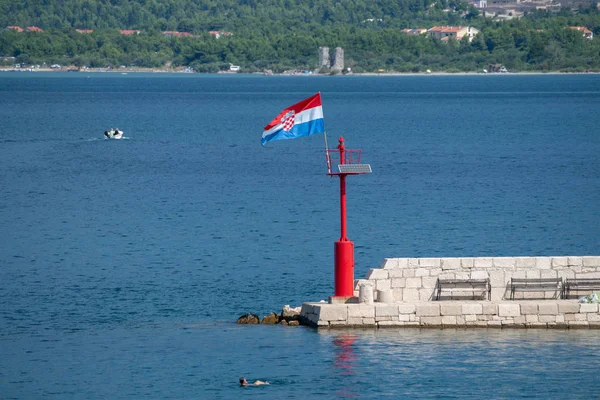 Deniz feneri Harbor üzerinde rüzgarda uçan Hırvat bayrak