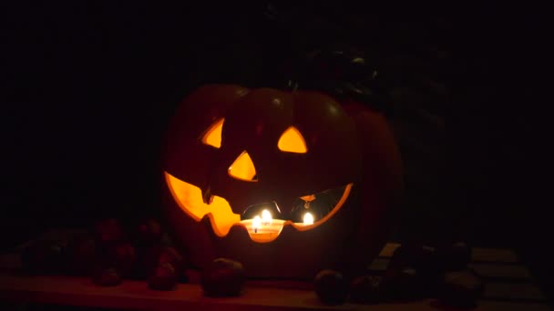 Тыква на Хэллоуин на темном фоне с орехами — стоковое видео