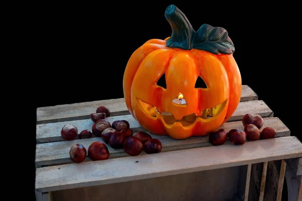 Halloween pumpa med kastanjer dekoration på trälåda — Stockfoto