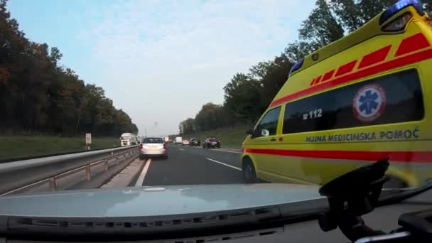 Ambulans med Räddningspersonal rusa förbi bilar på motorvägen — Stockvideo