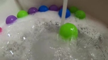 Banyo küveti su akışı tarafından yeşil plastik topu yuvarlandı
