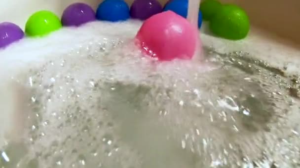 Rosafarbener Plastikball in Badewanne von Wasserstrahl gerollt, Zeitlupe — Stockvideo