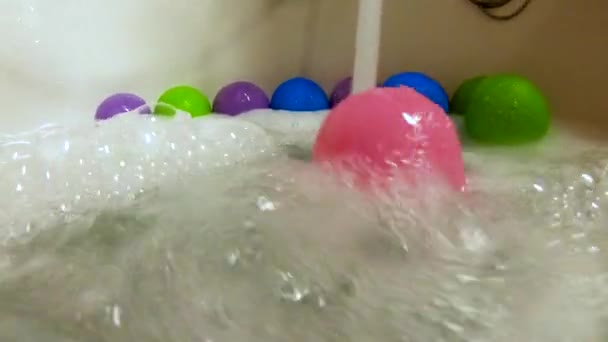 ピンクのプラスチック ボール圧延スローモーション浴槽の水の流れによって — ストック動画