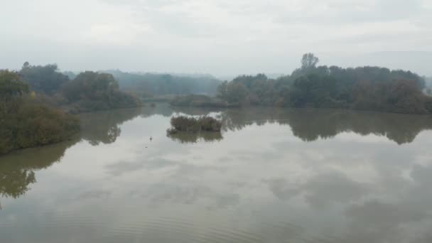 Panorering skott av en vacker reflekterande sjö i den slovenska landsbygden på en dimmig höst morgon — Stockvideo